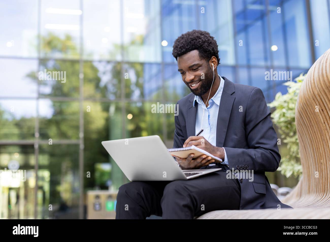 Geschäftsleute sitzen im Freien, nutzen Laptop und Notebook und genießen produktive Arbeitsverbindungen. Stockfoto