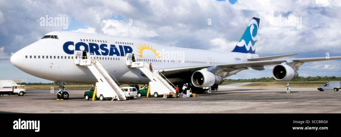 Panorama-Seite auf historischem 1998 Archivansicht des Boeing 747 Jumbo-Jet-Linienflugzeugs stationär auf Asphalt auf dem Santo Domingo Airport in der Dominikanischen Republik ein CORSAIR Airline-Geschäft in einem Archiv 90er-Jahre Bild von Bodenbesatzung und Nutzfahrzeugen bei der Arbeit, die sich auf den nächsten Flug vorbereiten. Ab 2022 wurde der Flughafen in Las Américas International umbenannt, der noch in derselben Dominikanischen Republik ansässig ist Stockfoto