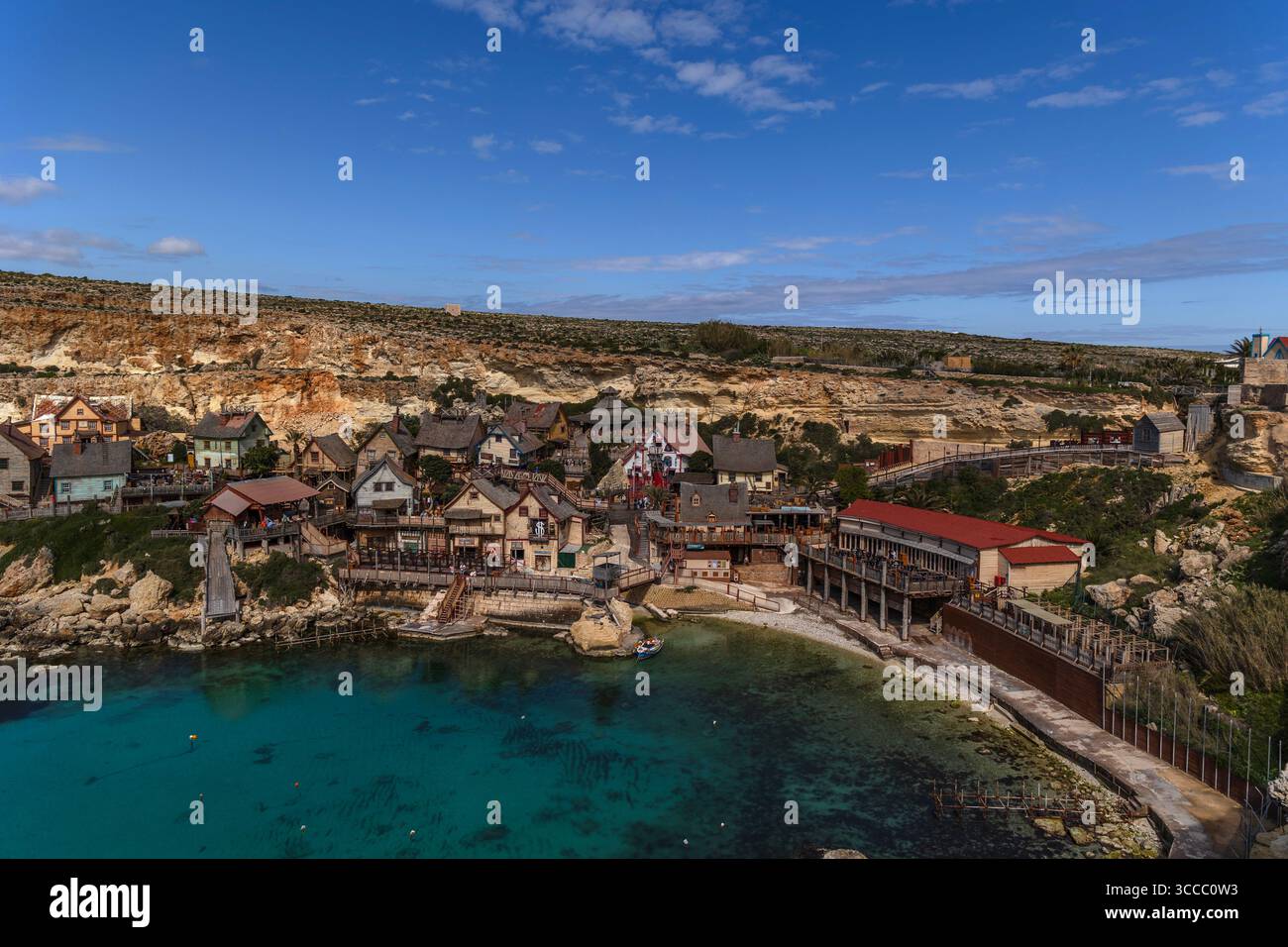 Mit Blick auf Popeye Village in Anchor Bay, Malta, an einem sonnigen Tag mit hellblauem Himmel und einem farbenfrohen Dorf mit Filmkulisse und Küste. Stockfoto