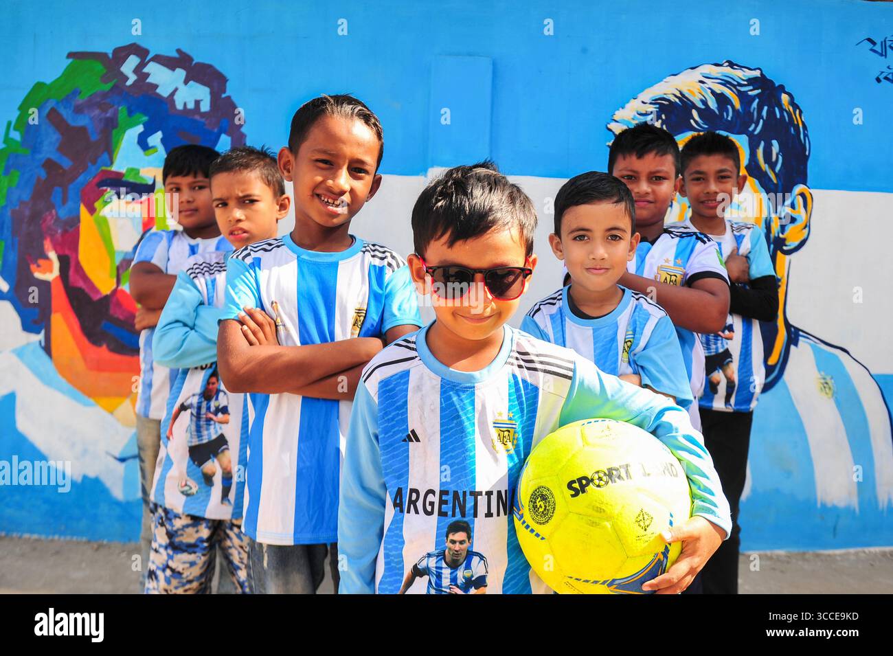 8. Dezember 2022, Sylhet, Bangladesch: 8. Dezember 2022 Sylhet-Bangladesch: Argentinien-Fans posieren auf der Straße von Sylhet, vor dem Gemälde Graffiti von DIEGO MARADONA und LIONEL MESSI von Argentinien. Bangladesch, ein solches Land, das nie für eine Fußball-Weltmeisterschaft qualifiziert wurde, aber große Liebe zum Fußball hat und riesige Fans sowohl für Argentinien als auch für Brasilien hat. (Bild: © MD Rafayat Haque Khan/ZUMA Press Wire) Stockfoto