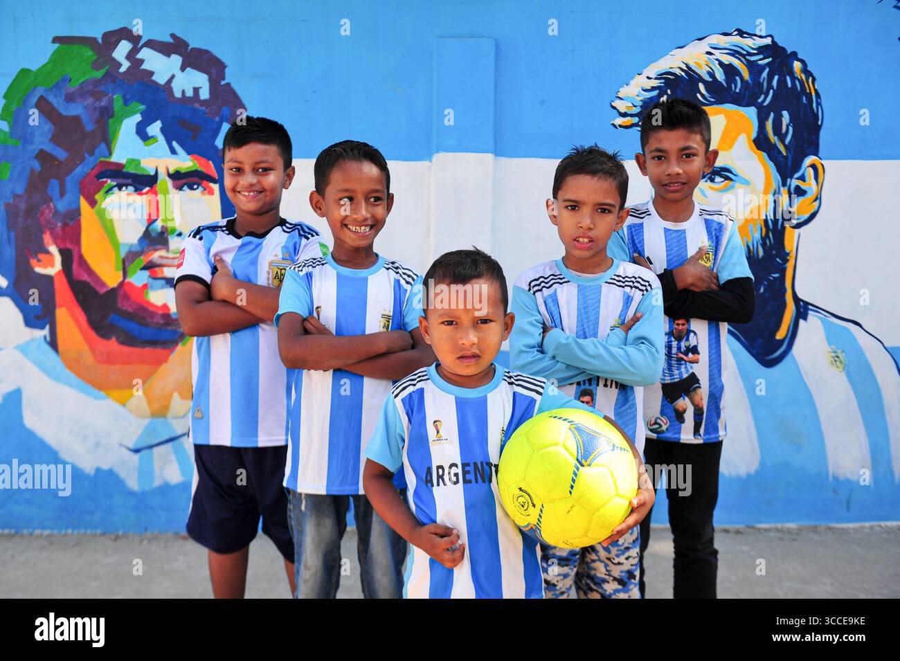 8. Dezember 2022, Sylhet, Bangladesch: 8. Dezember 2022 Sylhet-Bangladesch: Argentinien-Fans posieren auf der Straße von Sylhet, vor dem Gemälde Graffiti von DIEGO MARADONA und LIONEL MESSI von Argentinien. Bangladesch, ein solches Land, das nie für eine Fußball-Weltmeisterschaft qualifiziert wurde, aber große Liebe zum Fußball hat und riesige Fans sowohl für Argentinien als auch für Brasilien hat. (Bild: © MD Rafayat Haque Khan/ZUMA Press Wire) Stockfoto