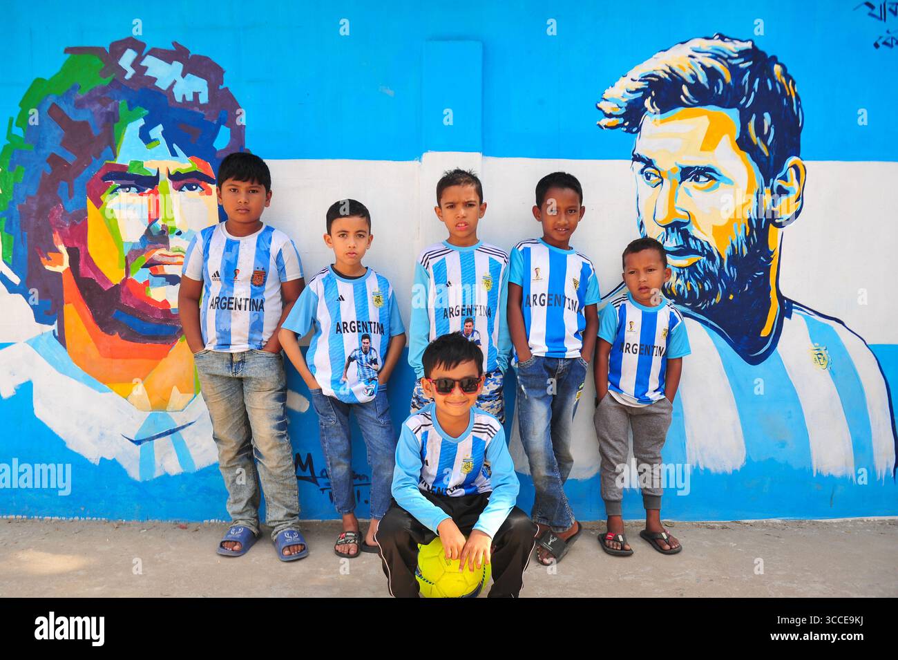8. Dezember 2022, Sylhet, Bangladesch: 8. Dezember 2022 Sylhet-Bangladesch: Argentinien-Fans posieren auf der Straße von Sylhet, vor dem Gemälde Graffiti von DIEGO MARADONA und LIONEL MESSI von Argentinien. Bangladesch, ein solches Land, das nie für eine Fußball-Weltmeisterschaft qualifiziert wurde, aber große Liebe zum Fußball hat und riesige Fans sowohl für Argentinien als auch für Brasilien hat. (Bild: © MD Rafayat Haque Khan/ZUMA Press Wire) Stockfoto