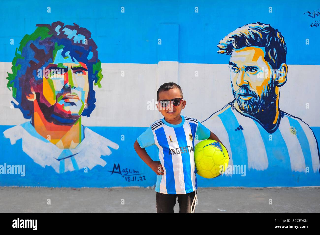 8. Dezember 2022, Sylhet, Bangladesch: 8. Dezember 2022 Sylhet-Bangladesch: Argentinien-Fans posieren auf der Straße von Sylhet, vor dem Gemälde Graffiti von DIEGO MARADONA und LIONEL MESSI von Argentinien. Bangladesch, ein solches Land, das nie für eine Fußball-Weltmeisterschaft qualifiziert wurde, aber große Liebe zum Fußball hat und riesige Fans sowohl für Argentinien als auch für Brasilien hat. (Bild: © MD Rafayat Haque Khan/ZUMA Press Wire) Stockfoto