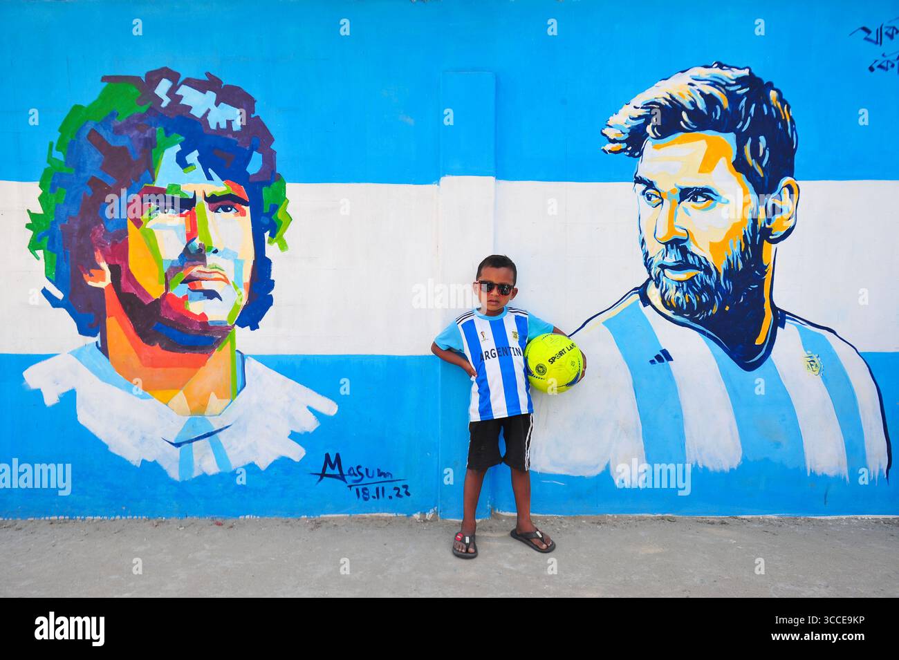 8. Dezember 2022, Sylhet, Bangladesch: 8. Dezember 2022 Sylhet-Bangladesch: Argentinien-Fans posieren auf der Straße von Sylhet, vor dem Gemälde Graffiti von DIEGO MARADONA und LIONEL MESSI von Argentinien. Bangladesch, ein solches Land, das nie für eine Fußball-Weltmeisterschaft qualifiziert wurde, aber große Liebe zum Fußball hat und riesige Fans sowohl für Argentinien als auch für Brasilien hat. (Bild: © MD Rafayat Haque Khan/ZUMA Press Wire) Stockfoto