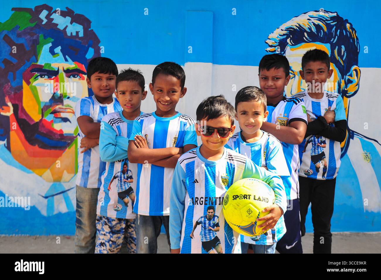 8. Dezember 2022, Sylhet, Bangladesch: 8. Dezember 2022 Sylhet-Bangladesch: Argentinien-Fans posieren auf der Straße von Sylhet, vor dem Gemälde Graffiti von DIEGO MARADONA und LIONEL MESSI von Argentinien. Bangladesch, ein solches Land, das nie für eine Fußball-Weltmeisterschaft qualifiziert wurde, aber große Liebe zum Fußball hat und riesige Fans sowohl für Argentinien als auch für Brasilien hat. (Bild: © MD Rafayat Haque Khan/ZUMA Press Wire) Stockfoto