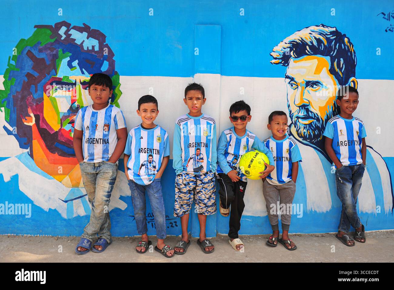 8. Dezember 2022, Sylhet, Bangladesch: 8. Dezember 2022 Sylhet-Bangladesch: Argentinien-Fans posieren auf der Straße von Sylhet, vor dem Gemälde Graffiti von DIEGO MARADONA und LIONEL MESSI von Argentinien. Bangladesch, ein solches Land, das nie für eine Fußball-Weltmeisterschaft qualifiziert wurde, aber große Liebe zum Fußball hat und riesige Fans sowohl für Argentinien als auch für Brasilien hat. (Bild: © MD Rafayat Haque Khan/ZUMA Press Wire) Stockfoto