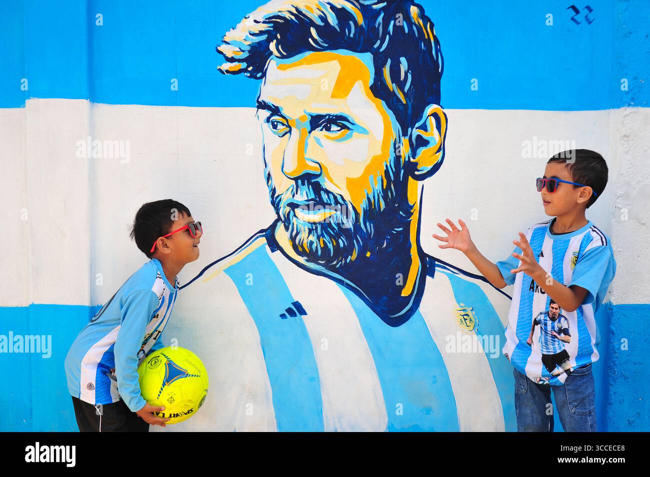 8. Dezember 2022, Sylhet, Bangladesch: 8. Dezember 2022 Sylhet-Bangladesch: Argentinien-Fans posieren auf der Straße von Sylhet, vor dem Gemälde Graffiti von DIEGO MARADONA und LIONEL MESSI von Argentinien. Bangladesch, ein solches Land, das nie für eine Fußball-Weltmeisterschaft qualifiziert wurde, aber große Liebe zum Fußball hat und riesige Fans sowohl für Argentinien als auch für Brasilien hat. (Bild: © MD Rafayat Haque Khan/ZUMA Press Wire) Stockfoto