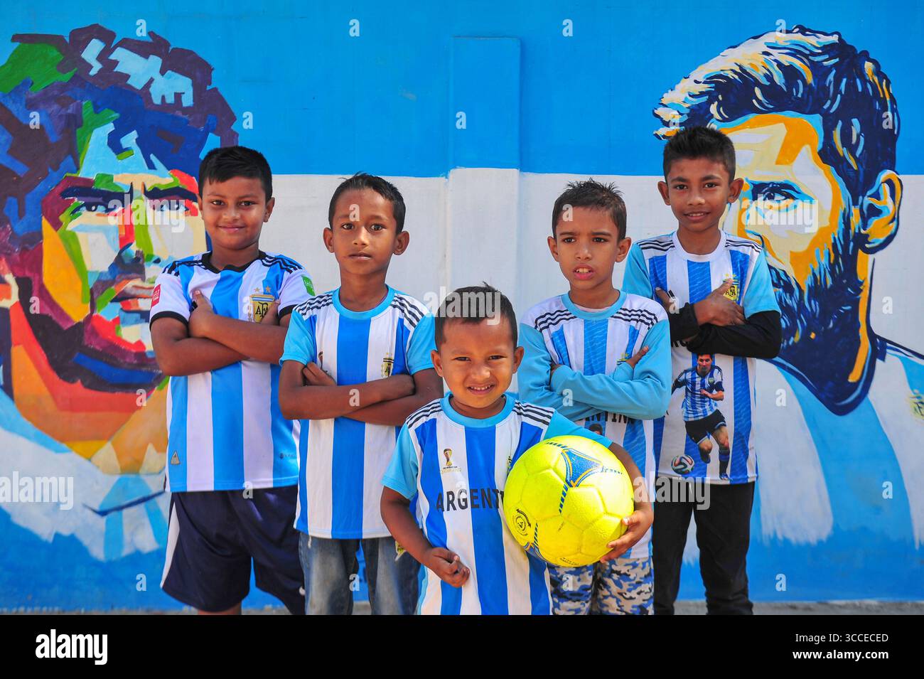 8. Dezember 2022, Sylhet, Bangladesch: 8. Dezember 2022 Sylhet-Bangladesch: Argentinien-Fans posieren auf der Straße von Sylhet, vor dem Gemälde Graffiti von DIEGO MARADONA und LIONEL MESSI von Argentinien. Bangladesch, ein solches Land, das nie für eine Fußball-Weltmeisterschaft qualifiziert wurde, aber große Liebe zum Fußball hat und riesige Fans sowohl für Argentinien als auch für Brasilien hat. (Bild: © MD Rafayat Haque Khan/ZUMA Press Wire) Stockfoto