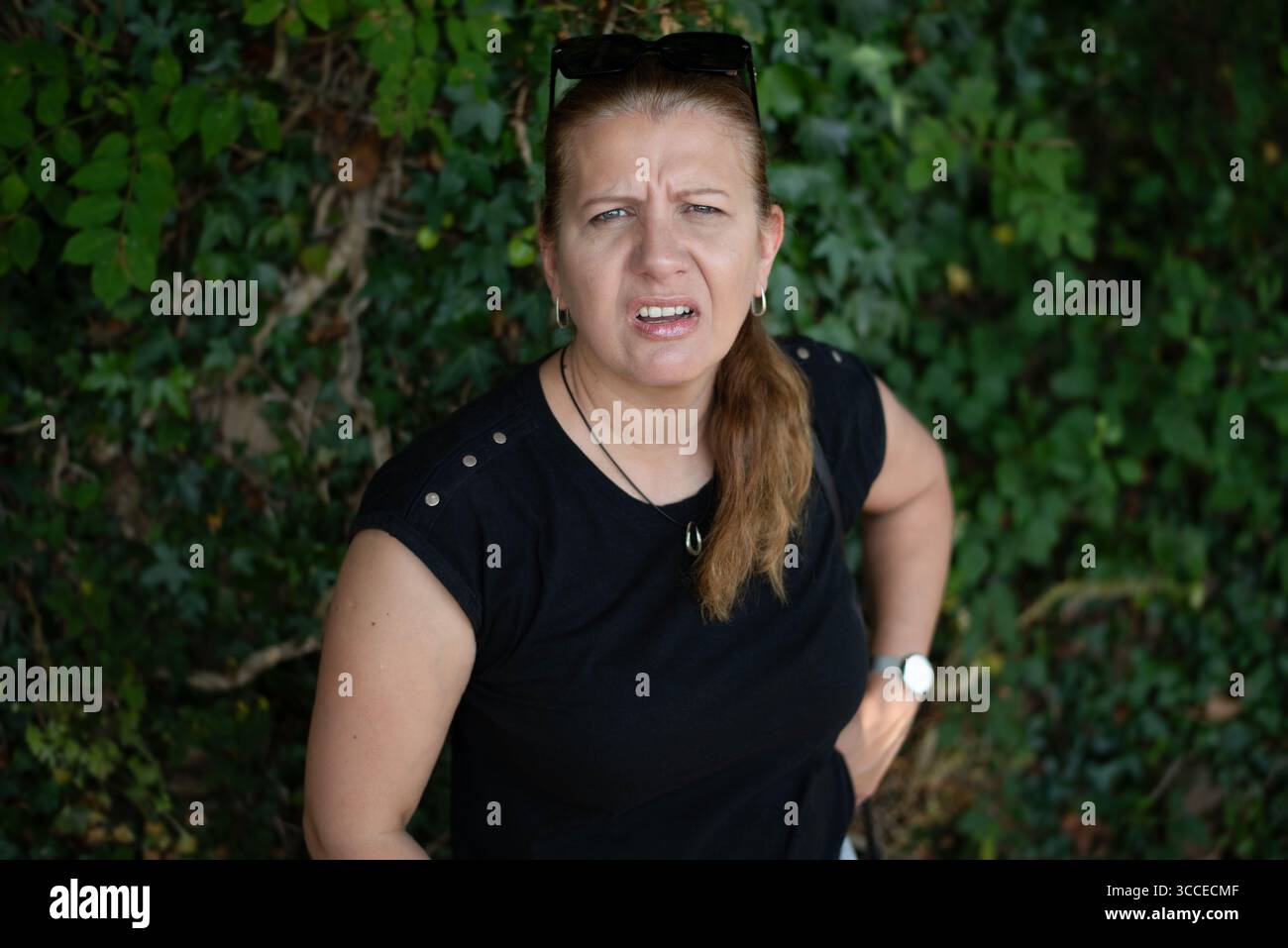 Eine Frau mit Gefühlen des Misstrauens, behauptet gegenüber jemandem, unzufrieden, bereit, die Beziehung zu klären. Eine Frau, die mit Emotionen steht Stockfoto