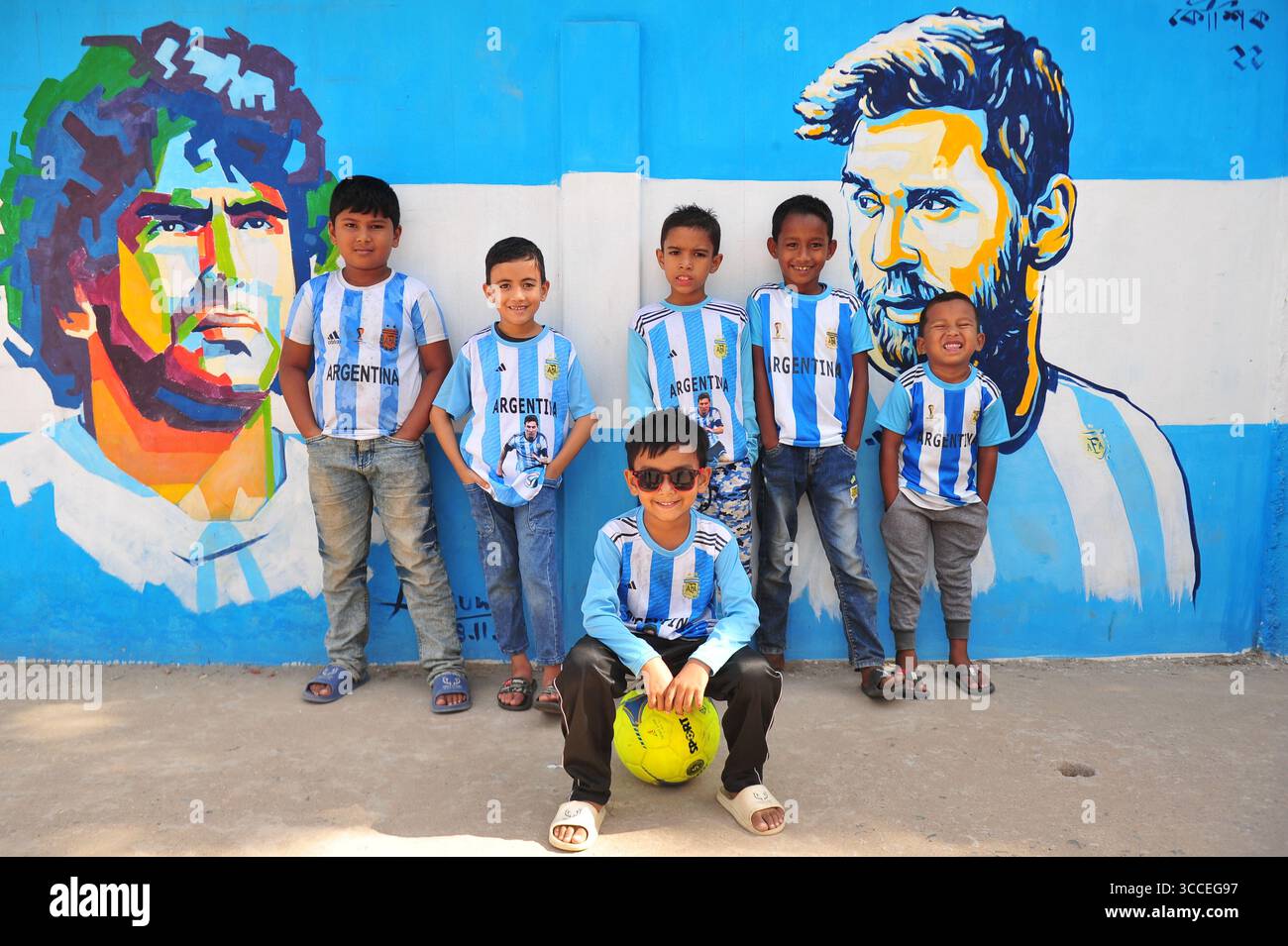 8. Dezember 2022, Sylhet, Bangladesch: 8. Dezember 2022 Sylhet-Bangladesch: Argentinien-Fans posieren auf der Straße von Sylhet, vor dem Gemälde Graffiti von DIEGO MARADONA und LIONEL MESSI von Argentinien. Bangladesch, ein solches Land, das nie für eine Fußball-Weltmeisterschaft qualifiziert wurde, aber große Liebe zum Fußball hat und riesige Fans sowohl für Argentinien als auch für Brasilien hat. (Bild: © MD Rafayat Haque Khan/ZUMA Press Wire) Stockfoto