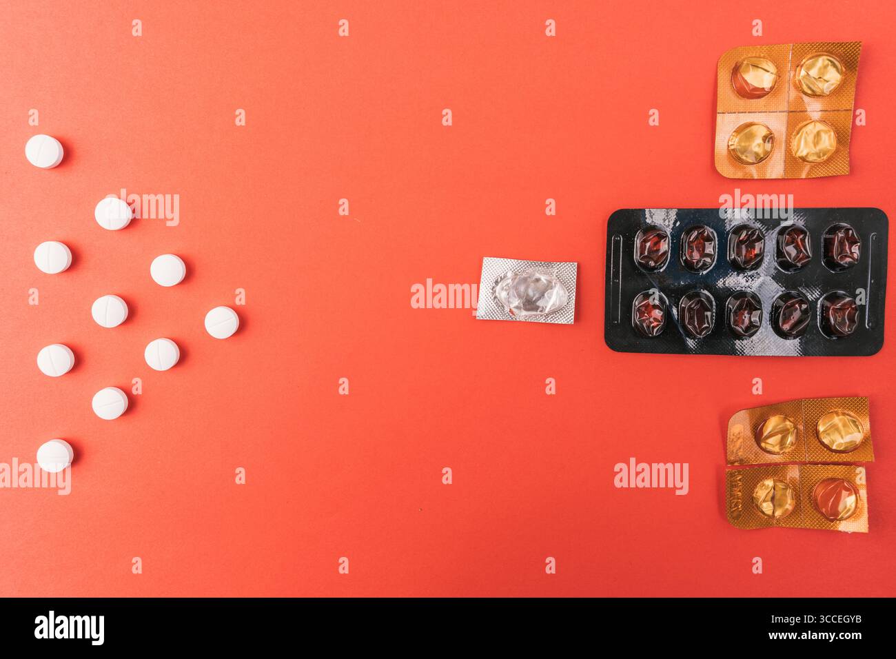 Leere Tabletten und Blisterpackungen in verschiedenen Formen auf einer leuchtend roten Oberfläche, Draufsicht Stockfoto
