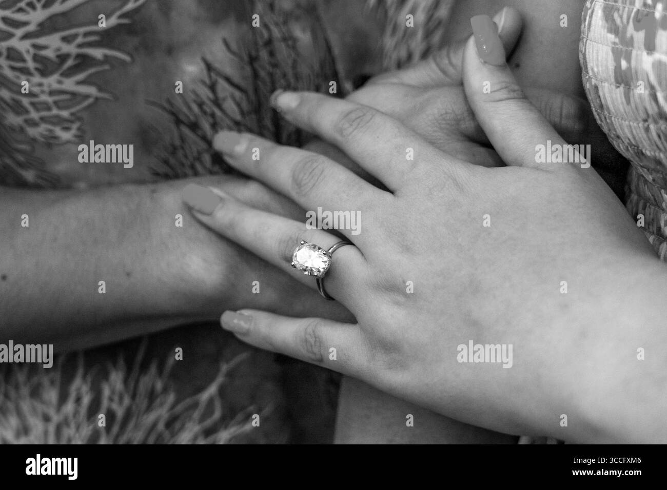 Nahaufnahme einer Damenhand mit Diamant-Verlobungsring, die einen ruhigen Moment der Liebe, Eleganz und des Versprechens für ewig zeitloses Engagement festhält Stockfoto