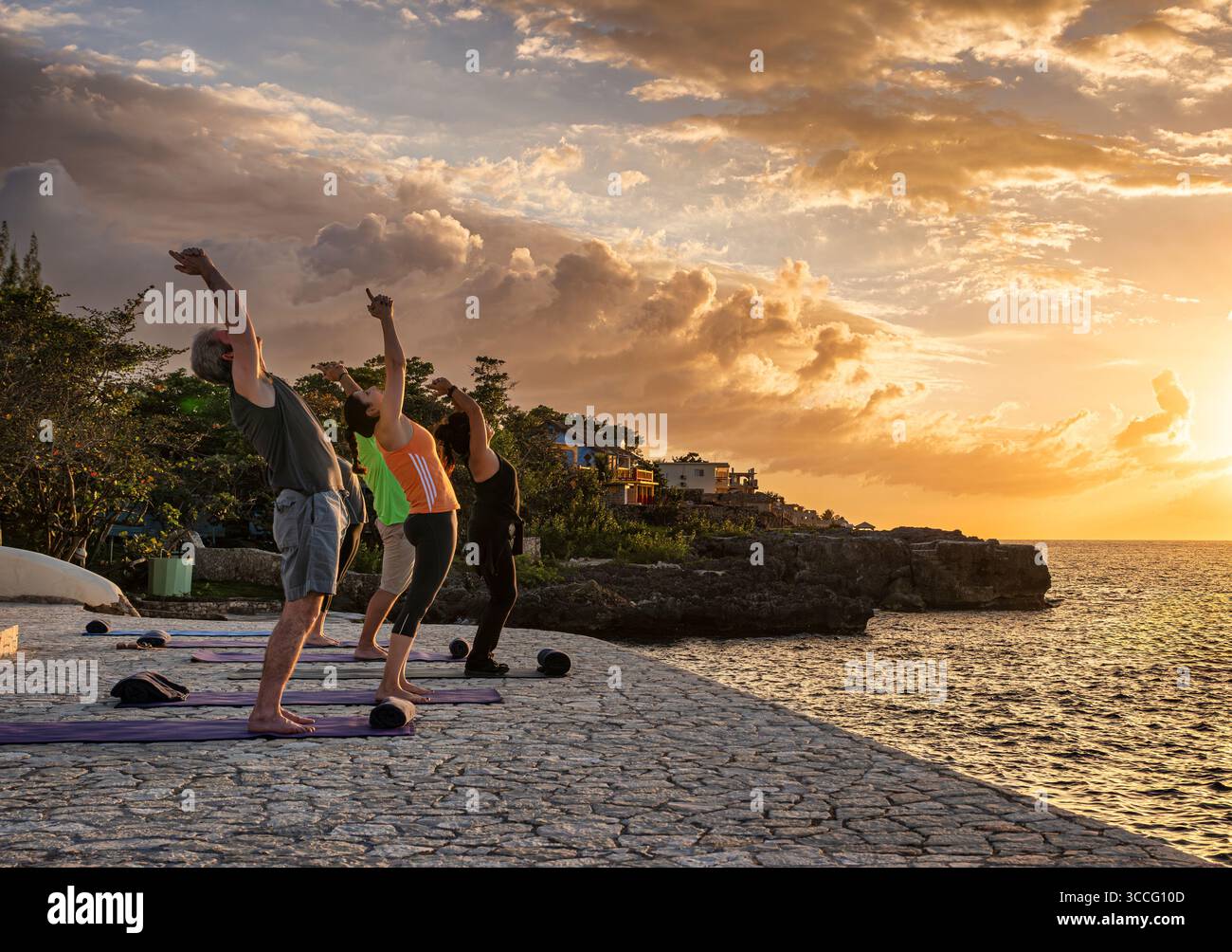 Yoga-Kurs bei Sonnenaufgang an der jamaikanischen Küste. Stockfoto