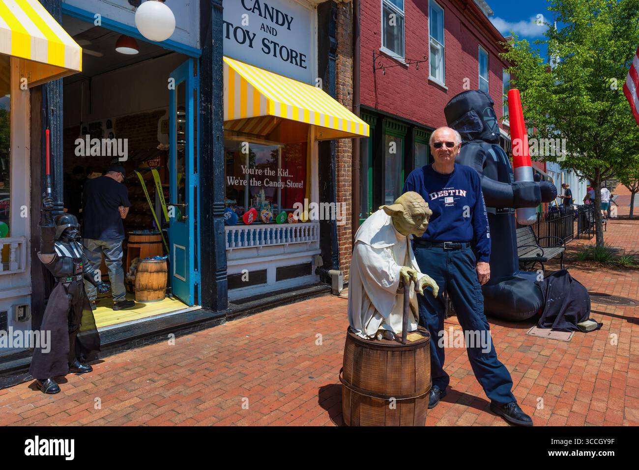 Jonesborough, Tennessee, USA – Mai 4,2025: Freiluftveranstaltung, bei der ein Mann neben dem Star war Theme-Dekor eines Geschäfts auf dem Bürgersteig posiert Stockfoto
