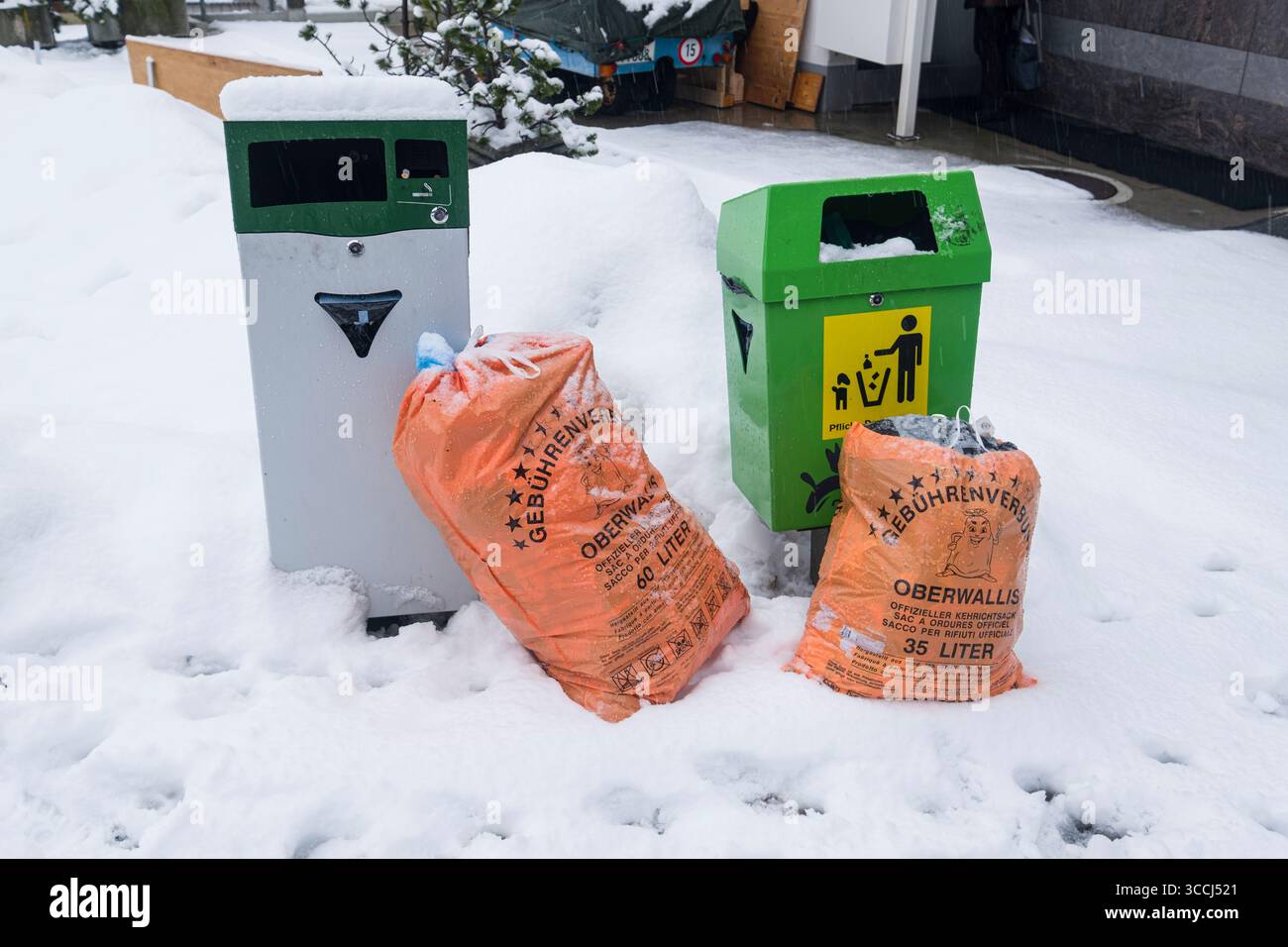 Orange Prepaid Müllsäcke zur Abholung in der kleinen Bergstadt SaaS-Fee, Visp, Wallis, Schweiz Stockfoto
