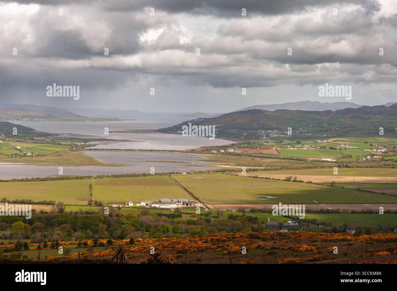 Ein bewölkter Tag mit Blick auf einen See und eine Stadt. Der Himmel ist bedeckt und das Wasser ist ruhig. Die Stadt ist klein und friedlich, mit Häusern und Gebäuden sc Stockfoto