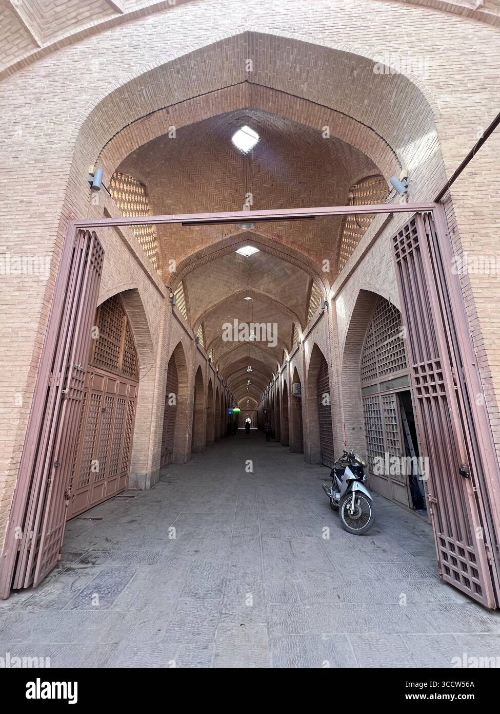 Gewölbte Backsteinbögen eines traditionellen Basarkorridors in Isfahan, Iran, mit persischer Architektur und historischem Marktplatzdesign. Stockfoto Gewölbte Backsteinbögen eines traditionellen Basarkorridors in Isfahan, Iran, mit persischer Architektur und historischem Marktplatzdesign. Stockfoto