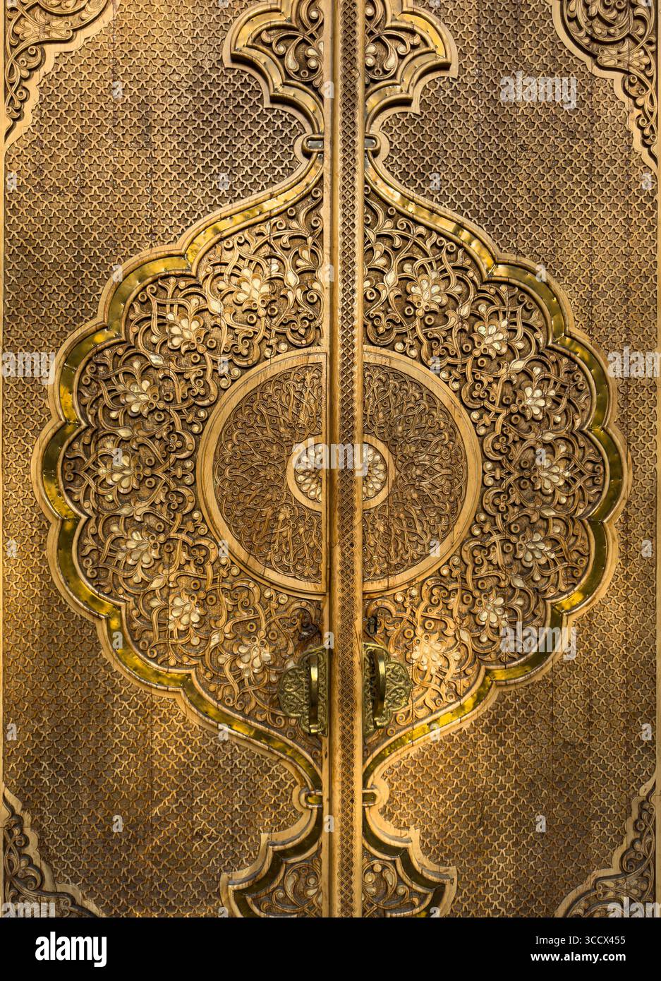 Nahaufnahme einer reich verzierten goldenen orientalischen Tür mit komplizierten Blumen- und geometrischen Mustern im traditionellen islamischen Stil Stockfoto