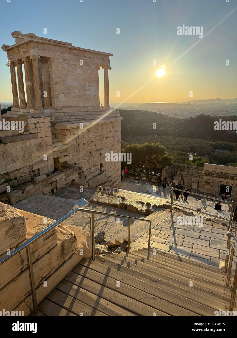 Goldene Stunde Sonnenuntergang am Eingang des Akropolis-Komplexes (Acrópole Propileia) in Athen, Griechenland, mit Touristen, die die Treppe hinunter laufen. Stockfoto