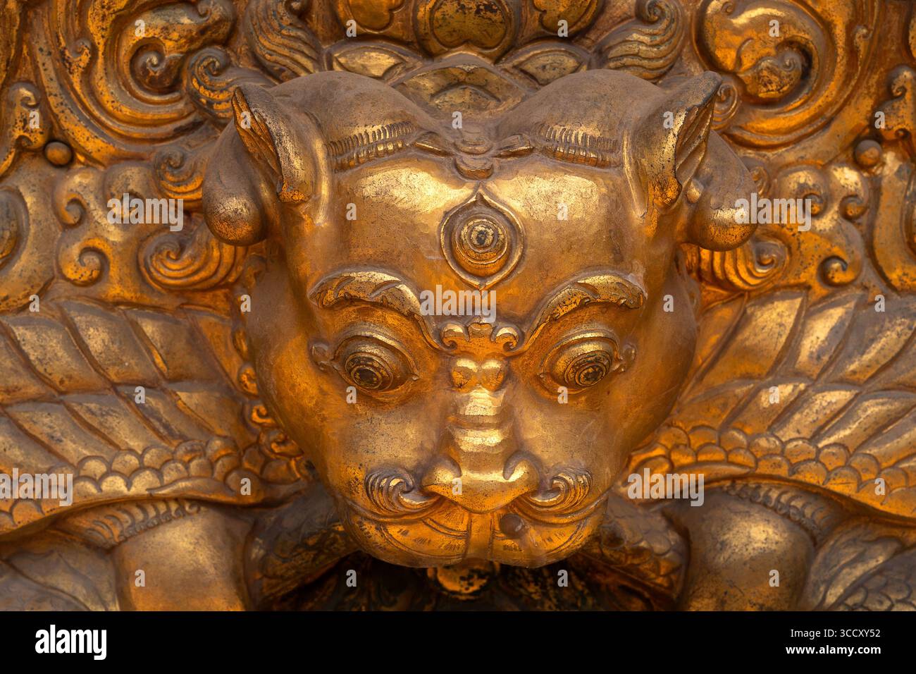 Nahaufnahme einer zornigen tibetisch-buddhistischen Gottheit in goldener Zierstatue, die Schutz und Zerstörung bösartiger Geister symbolisiert. Stockfoto