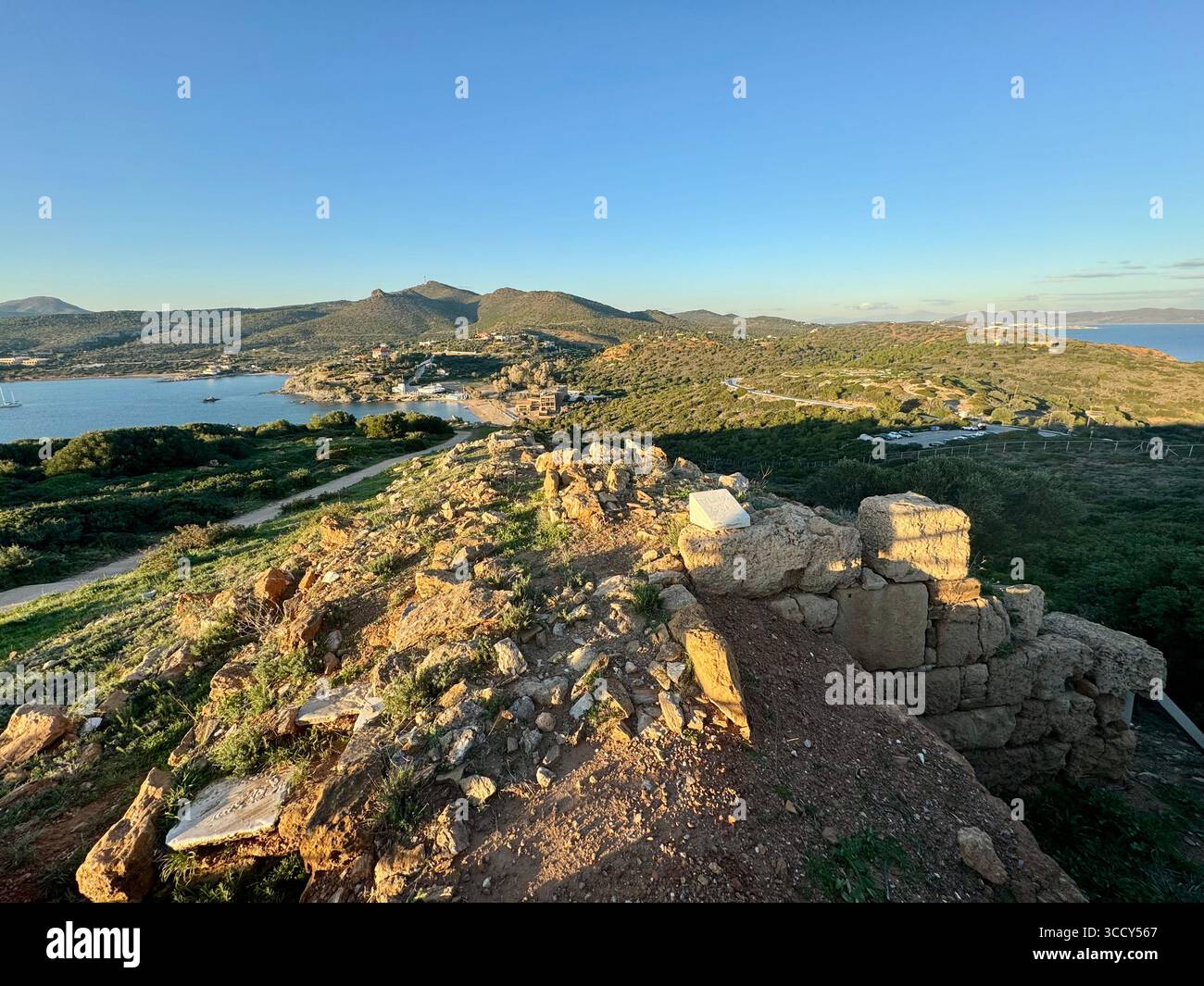 Panoramablick von der archäologischen Stätte Kap Sounion mit dem Tempel des Poseidon im Hintergrund und informativen Schildern für Besucher. Stockfoto