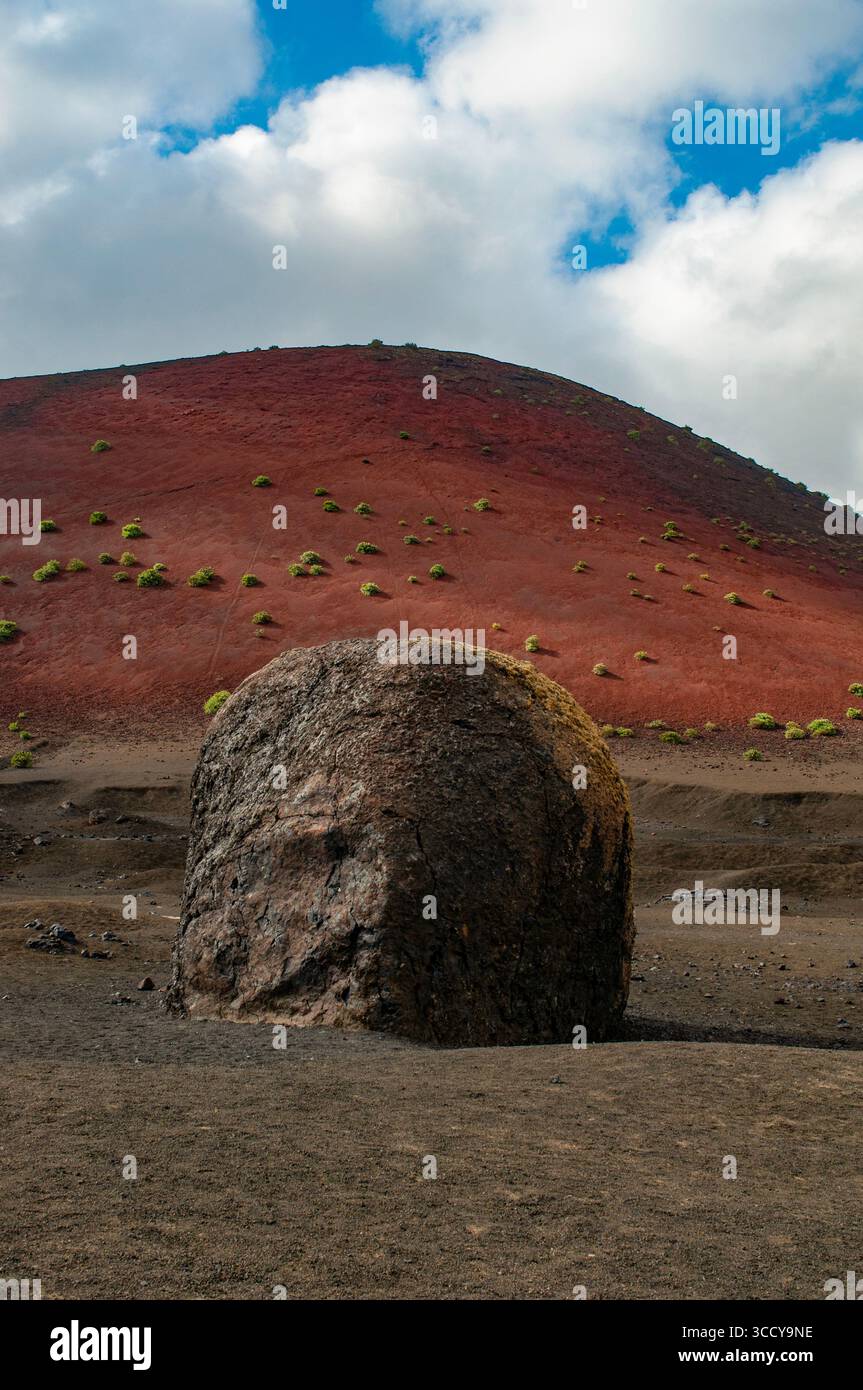 Lanzarote, Kanarische Inseln: Die Vulkanbombe, eine große Gesteinsmasse, die während eines Ausbruchs in der Nähe von Montana Colorada, einem prominenten rötlichen Vulkan, ausgeworfen wurde Stockfoto