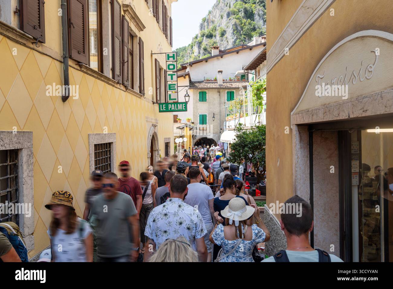 Limone sul Garda, Lombardei, Italien - 7. August 2025: Sommer in Limone sul Garda: Menschenmassen drängen sich in den engen Gassen der Altstadt. Der Massentourismus am Gardasee ist spürbar. Urlaubsatmosphäre trifft auf Hitze, enge und wenig Platz zwischen Fassaden und Geschäften *** Sommer in Limone sul Garda: Menschenmengen drängen durch die enge Altstadtgasse. Der Massentourismus am Gardasee ist spürbar. Urlaubsstimmung trifft auf Hitze, enge und wenig Platz zwischen Fassaden und Läden Stockfoto