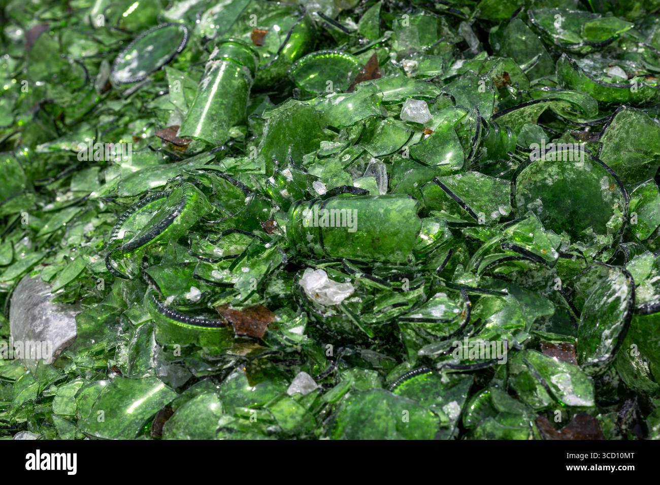 Ein großer Haufen von gebrochenem grünem Glas, das wahrscheinlich zum Recycling oder als Zuschlagstoff, z. B. für Terrazzoböden, bestimmt ist Stockfoto
