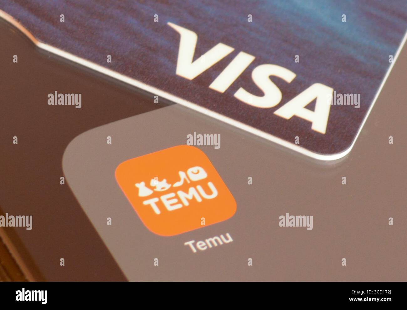 Temu Shopping-App auf einem Smartphone-Bildschirm mit einer VISA-Karte für die Zahlung Stockfoto