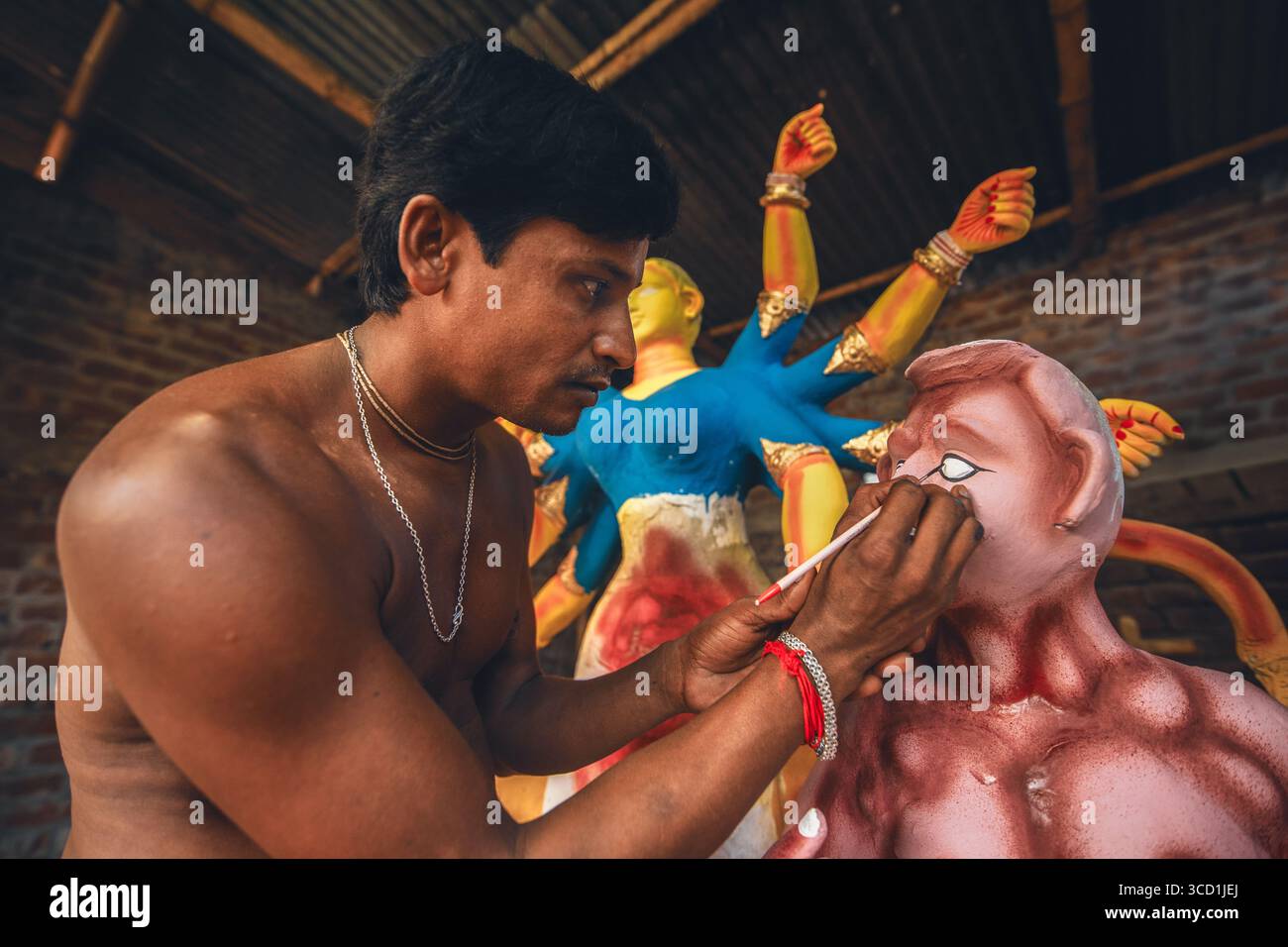 Bogura, Bangladesch - 16. Oktober 2020: Blick auf einen fokussierten Handwerker, der akribisch ein lebendiges Durga-Idol malte und die mythologische Figur mit geschickten Streicheln zum Leben erweckte. Stockfoto