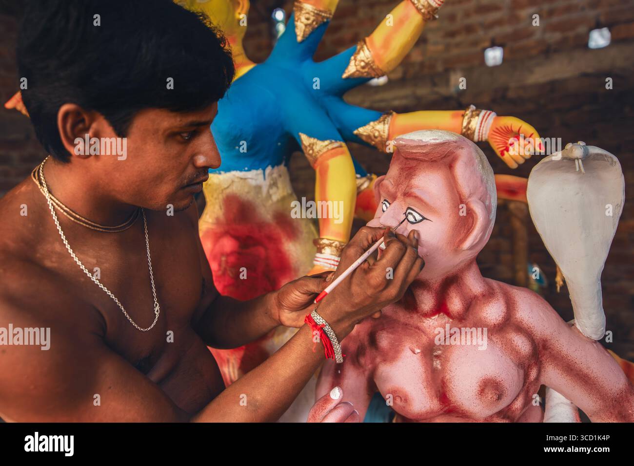 Bogura, Bangladesch - 16. Oktober 2020: Blick eines Künstlers, der akribisch die Augen eines Durga-Idols malte, die lebendigen Farben erwecken den Ton zum Leben Stockfoto