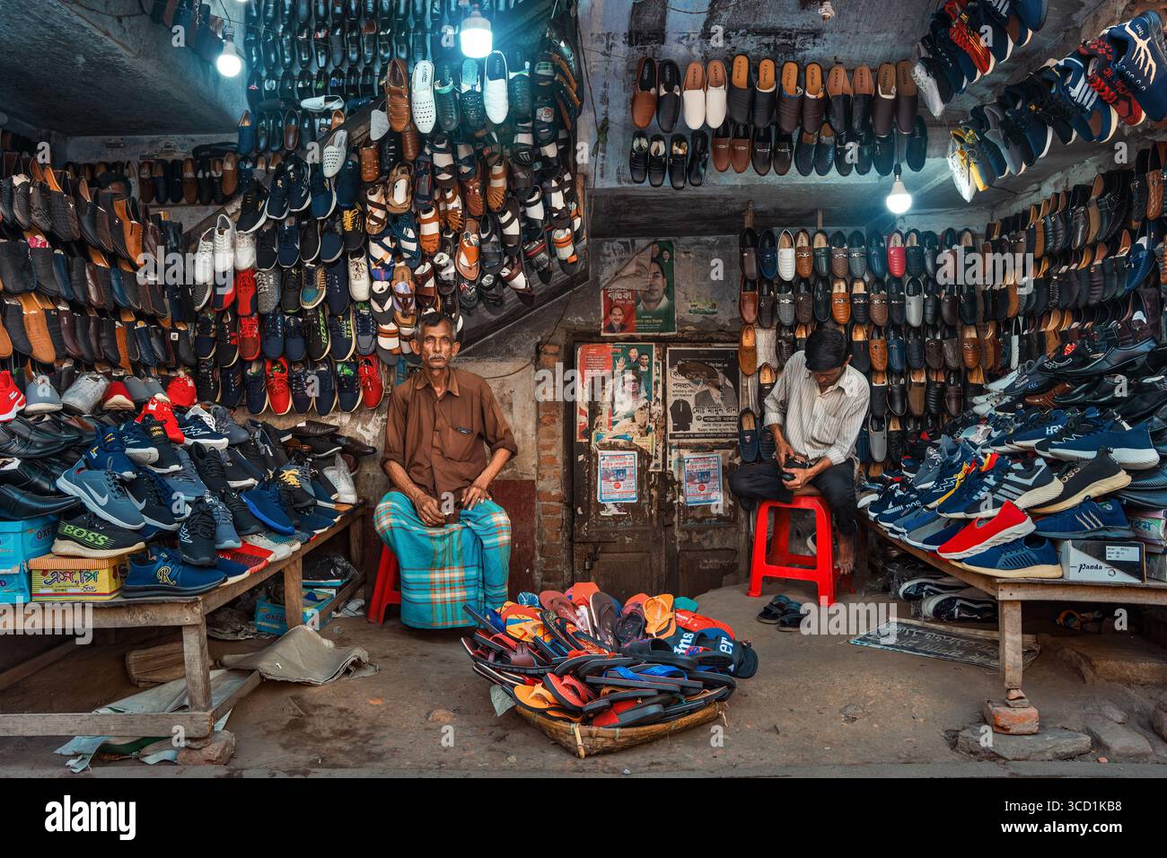 Bogura, Bangladesch - 24. März 2022: Blick auf ein belebtes Schuhgeschäft mit einem Kaleidoskop aus Schuhen, Texturen und Farben. Stockfoto