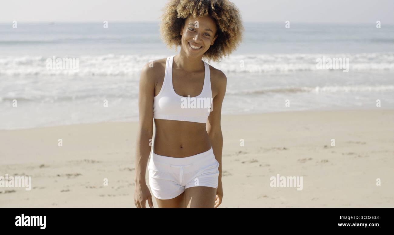 Afroamerikanische Frau Sportswear gehen vom Meer entfernt in Zeitlupe Stockfoto