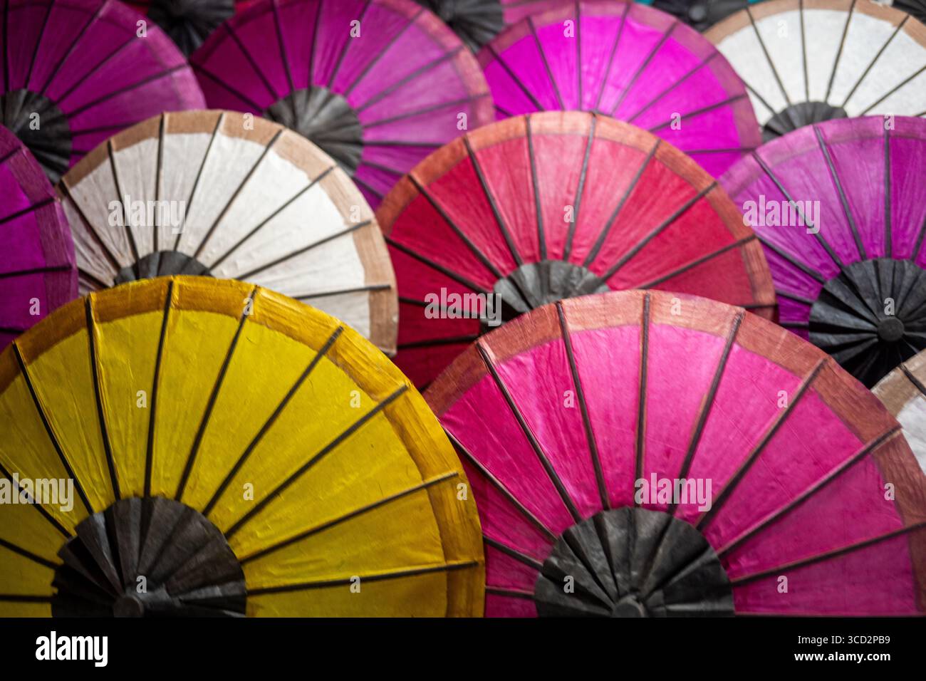 Farbenfrohe traditionelle handgefertigte Papierschirme, ausgestellt auf dem Luang Prabang Nachtmarkt, Laos – südostasiatische Handwerkskunst und Kultur Stockfoto