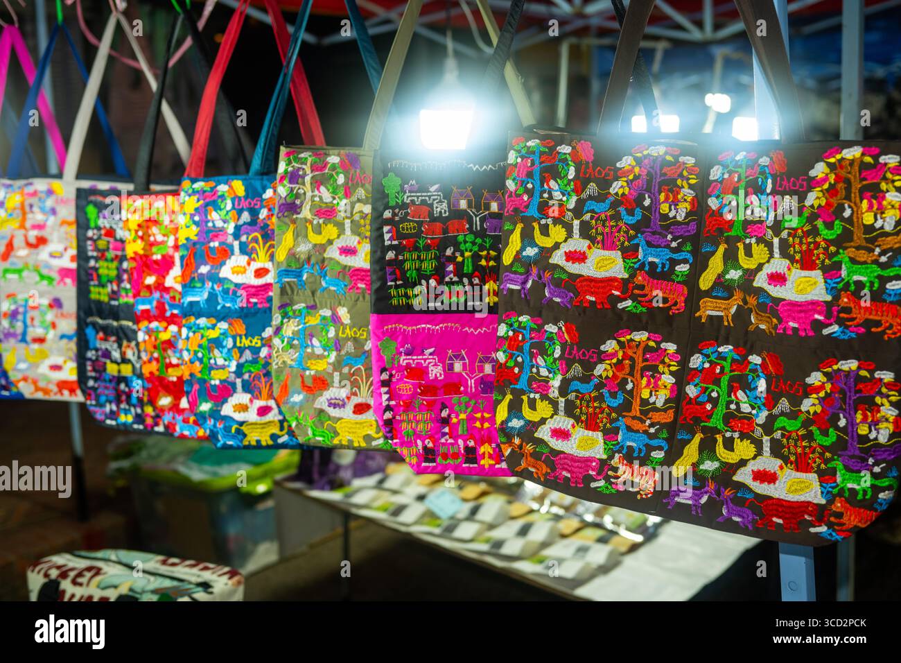 Farbenfrohe handgefertigte Taschen auf dem Nachtmarkt Luang Prabang in Laos – traditionelles Textilhandwerk zum Verkauf Stockfoto