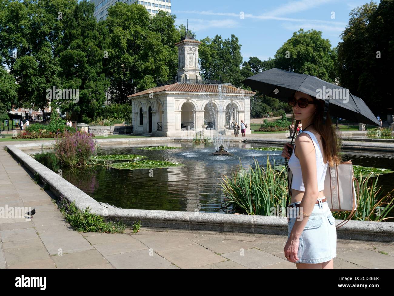London, Großbritannien. August 2025. Leute draußen in den Italian Gardens in Kensington Gardens, London. Bernsteinfarbene Hitzewarnungen wurden in großen Teilen Englands ausgegeben, da die Temperaturen voraussichtlich in die Höhe steigen werden. August 2025 BensCapMedia/Alamy Live News Stockfoto
