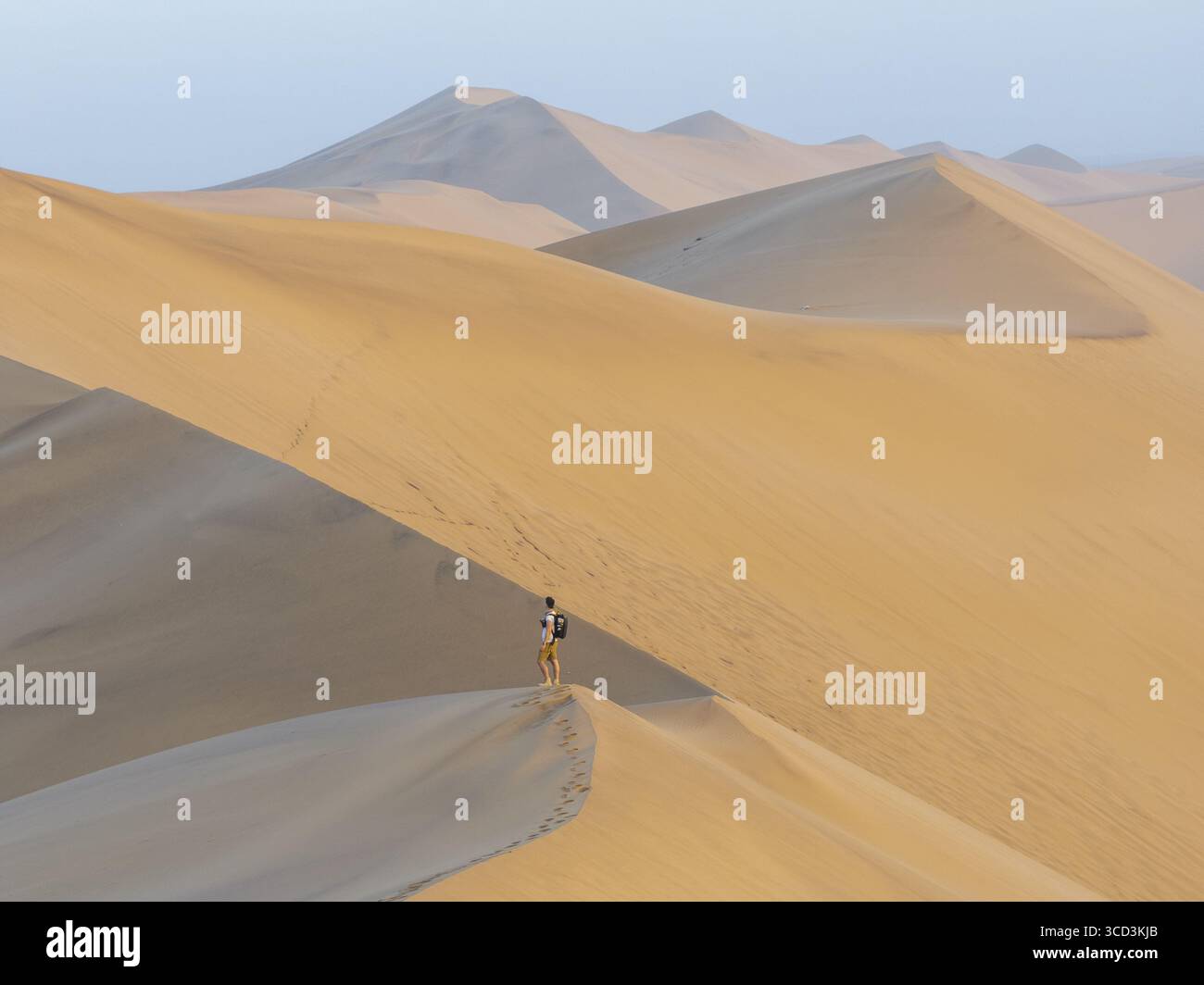 Luftaufnahme der Düne 7 mit einem Mann, der während des Sonnenuntergangs am Rand steht, Erongo, Namibia. Stockfoto