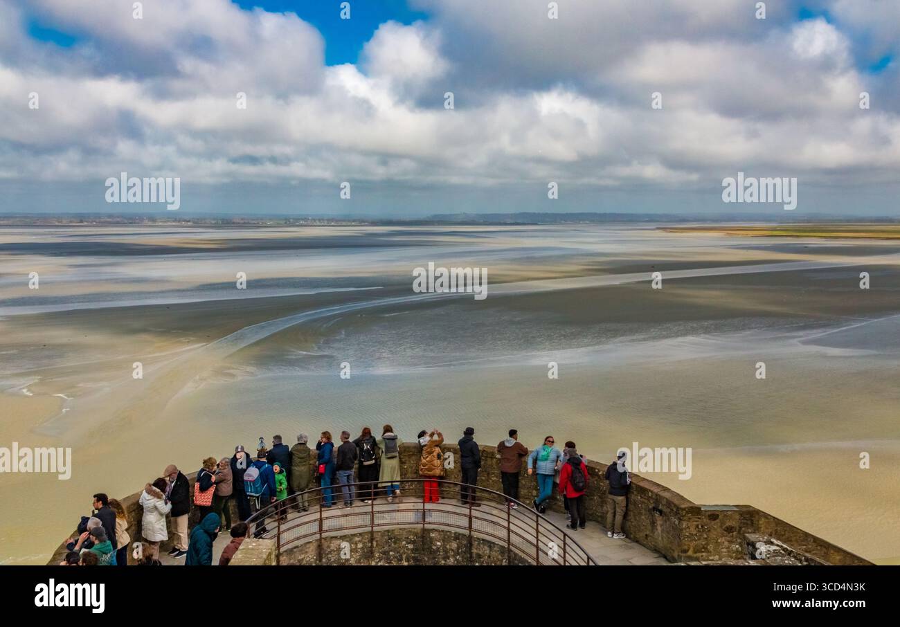 Besucher stehen auf dem Nordturm (Tour du Nord), einem runden mittelalterlichen Wachturm, der auf einem Felsvorsprung entlang der Stadtmauer von Mont-Saint-Michel thront... Stockfoto