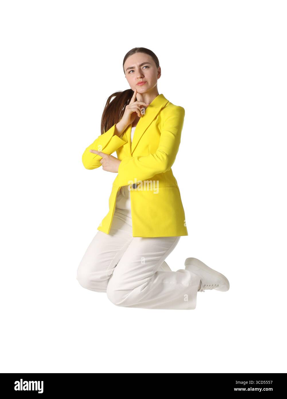 Frau in gelber Jacke, die auf weißem Hintergrund springt Stockfoto