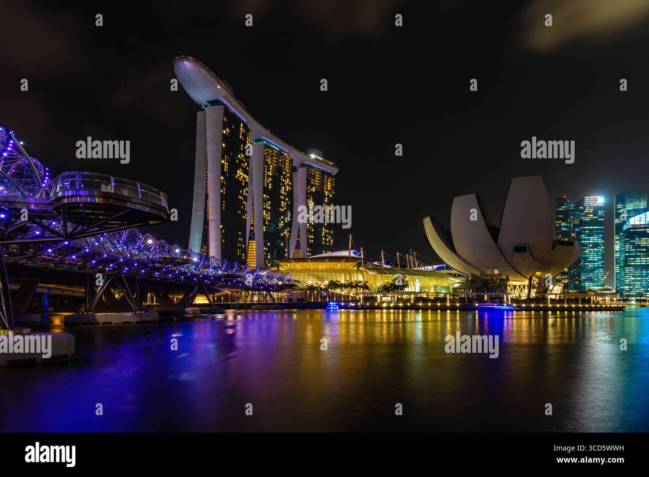 singapur - Marina Bay mit Helix Bridge, Marina Bay Sands Hotel und Kunstmuseum beleuchtet bei Nacht Stockfoto