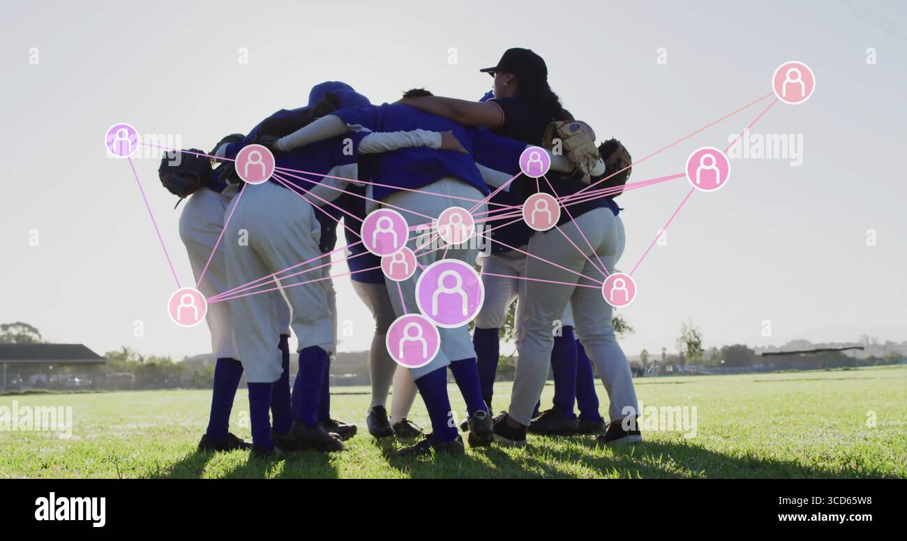 Sieben Softballspieler, die Handschuhe halten, verbinden ihre Arme auf dem Feld mit pinkem Netzwerk Stockfoto