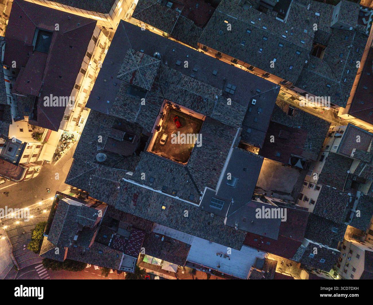 Aus der Vogelperspektive veraltete Dächer, die in das schwindende Licht der Dämmerung getaucht sind, enthüllt die architektonischen Details der Gebäude, Sulmona, Abruzzen, Italien. Stockfoto