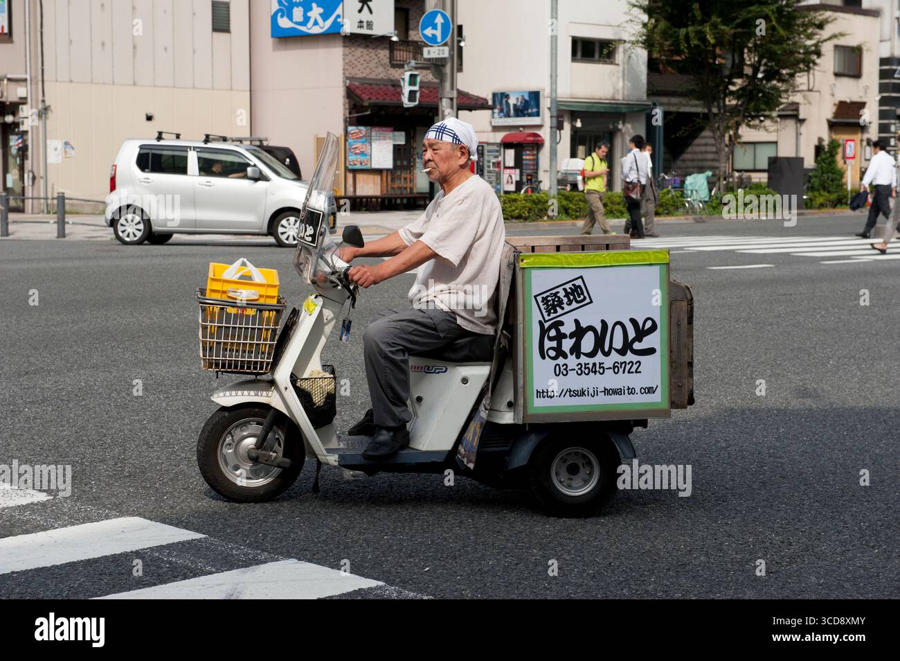 Liefermann raucht eine Zigarette auf einem Roller in Tokio, Japan. Tokio, offiziell Tokio Metropolis, ist eine der 47 Präfekturen Japans. Stockfoto