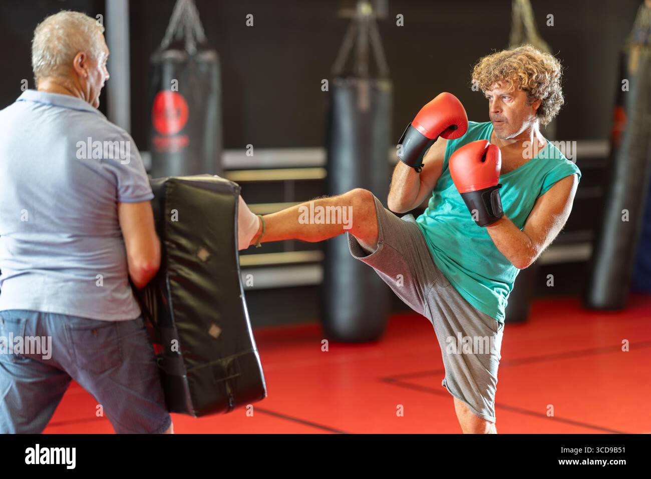 Mann mittleren Alters schlägt Schild in Selbstverteidigungsbohrung Stockfoto