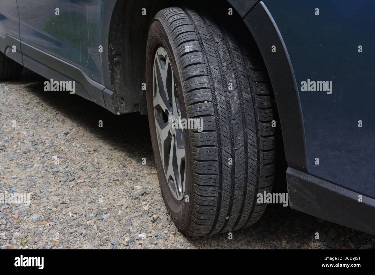 Eine Nahaufnahme eines Autoreifens auf einer Schotterstraße Stockfoto