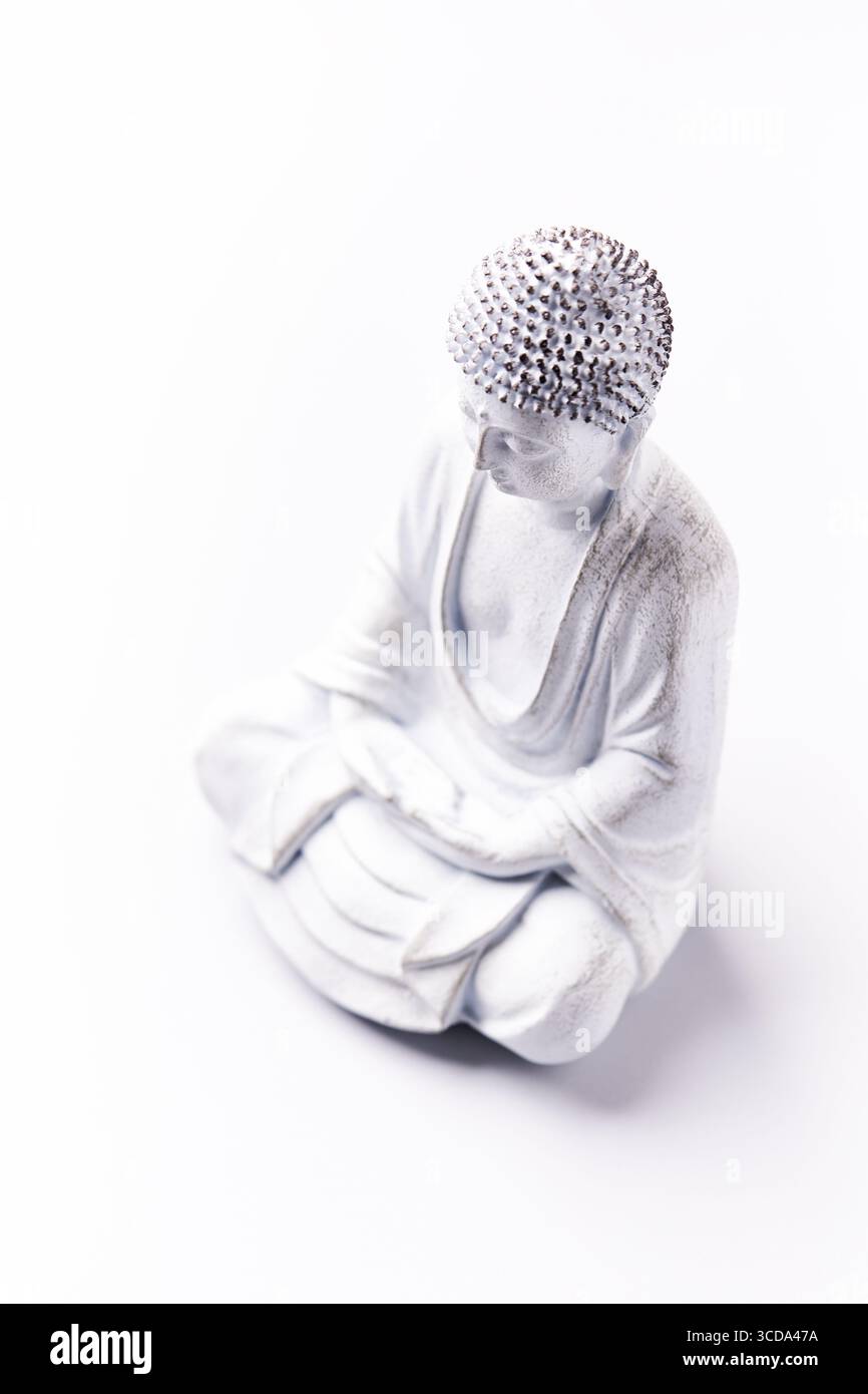 Meditierende Buddha Statue auf hellem Hintergrund. Weichfokus. Speicherplatz kopieren. Stockfoto