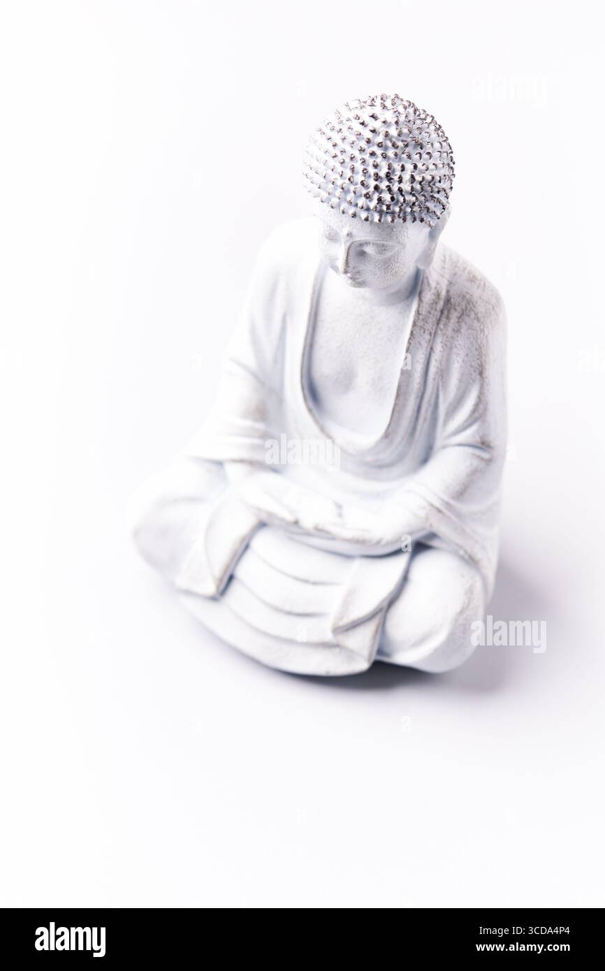 Meditierende Buddha Statue auf hellem Hintergrund. Weichfokus. Speicherplatz kopieren. Stockfoto
