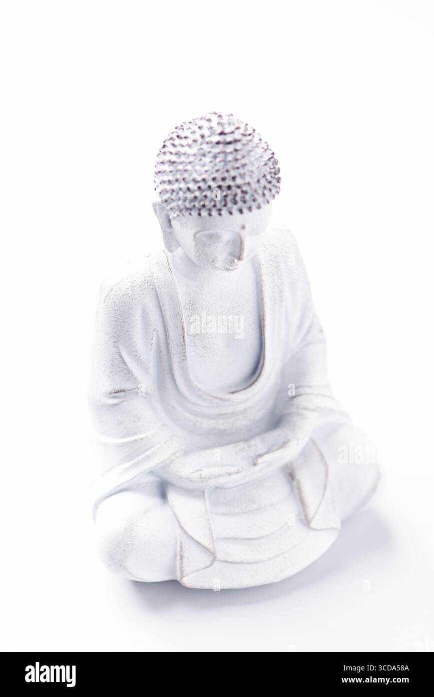 Meditierende Buddha Statue auf hellem Hintergrund. Weichfokus. Speicherplatz kopieren. Stockfoto