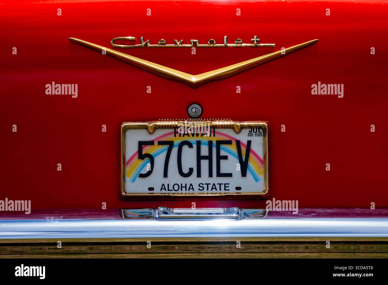 Kräftig rot 1957 Chevy Bel Air parkte im Sonnenlicht und präsentierte sein Chrom und seine Kurven. Eine zeitlose amerikanische Autokultur mit Nostalgie und Vintage Stockfoto