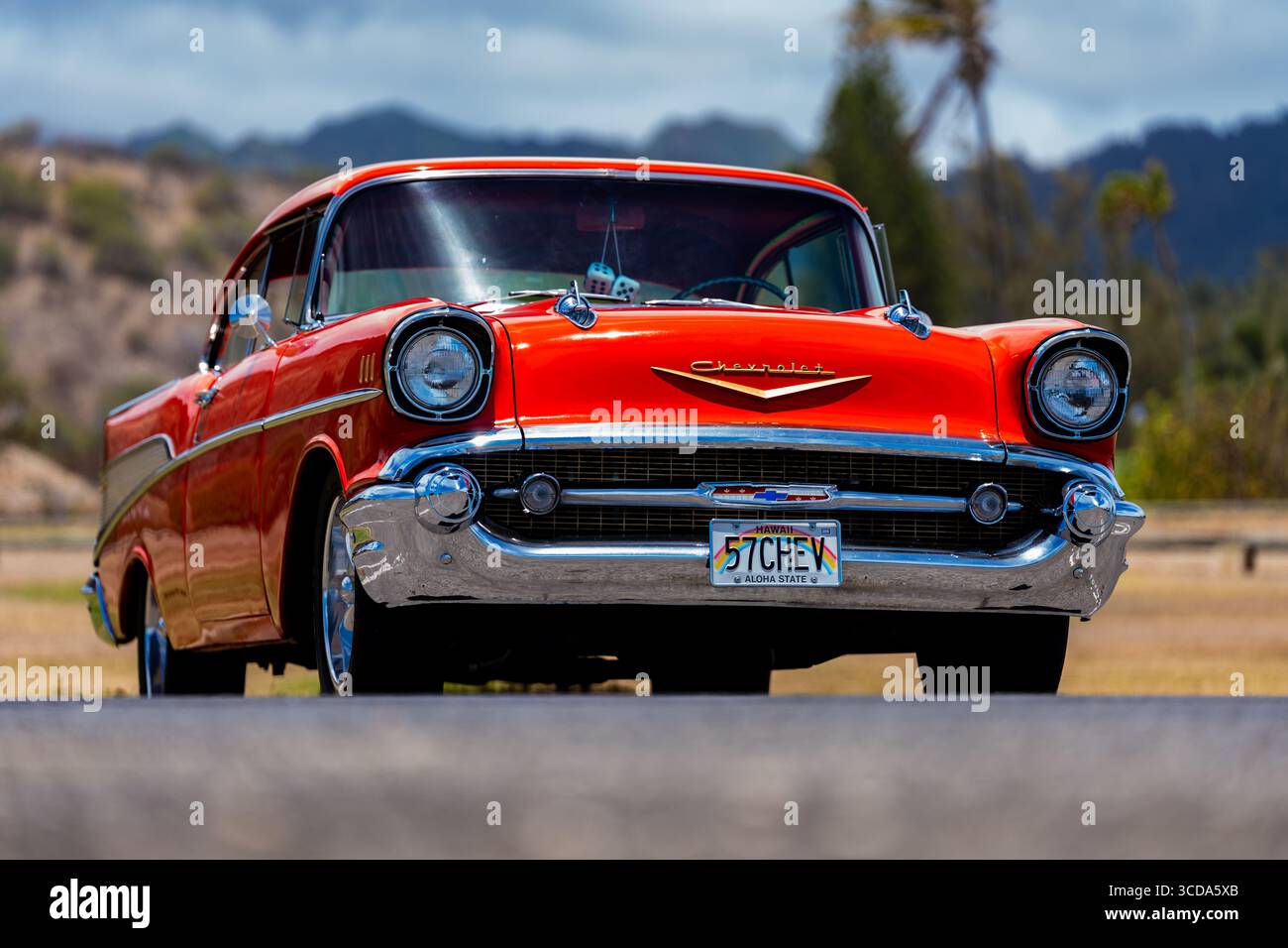 Kräftig rot 1957 Chevy Bel Air parkte im Sonnenlicht und präsentierte sein Chrom und seine Kurven. Eine zeitlose amerikanische Autokultur mit Nostalgie und Vintage Stockfoto